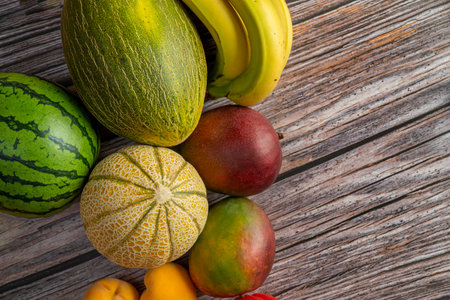 Top view image of ripe African mangoes, European melons and watermelons, canary bananas and yellow...