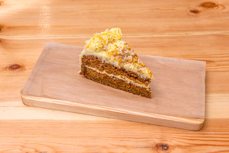 Portion of industrial carrot cake with a delicious appearance with whipped cream and carrot zest and...