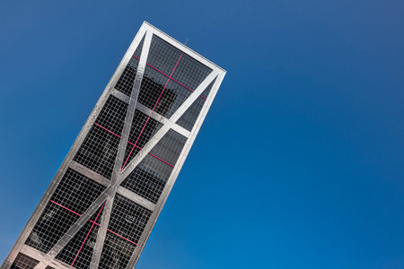 Low angle image of a metal and glass building with leaning architecture of the Plaza de Castilla in...