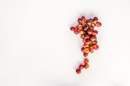 Bunch of claret dessert grapes viewed from the top on plain white backgroundの写真素材