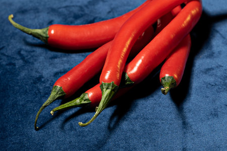 Bunch of red hot chili peppers on blue velvet fabric
