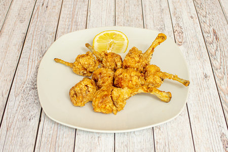Portion of fried chicken wings with lemon to garnishの写真素材