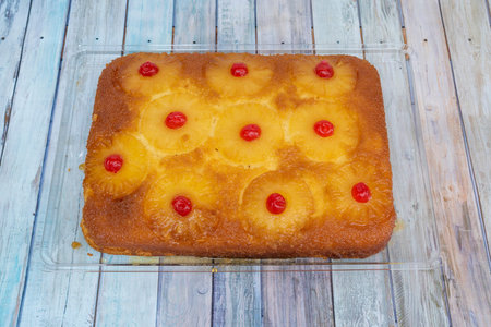 large pineapple tart with candied cherries and roasted pineapple slices on moist sponge cakeの写真素材