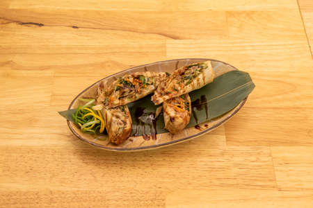Crispy Vietnamese duck rolls stewed with vegetables on banana leaf and soy sauceの写真素材