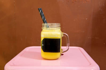fruit juice in glass jug with black strawの写真素材