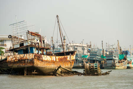 Fishing port with moored boats and some ruined on the coast of Phuket city in Thailandの写真素材