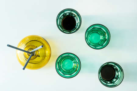 Top view image of green glasses and a yellow vase on white backgroundの写真素材
