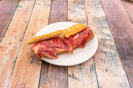 Acorn-fed ham sandwich on white plateの写真素材