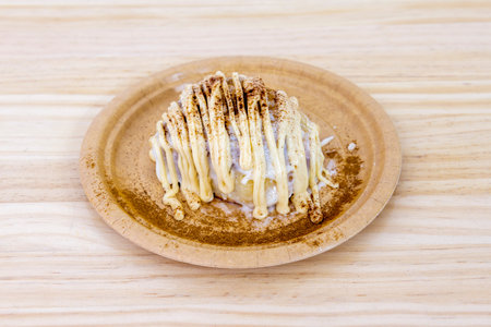 White chocolate cinnamon roll on cardboard plateの写真素材