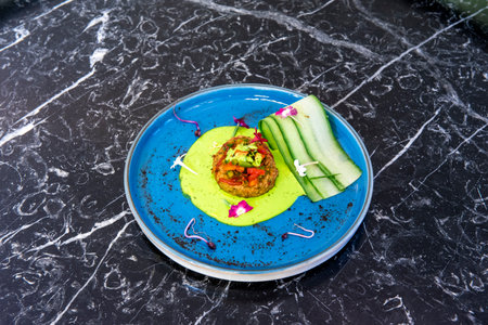 Vegetable cutlet with cucumber slices, flowers and red cabbage shoots with green sauce cooked by a Hindu chefの写真素材