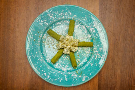 Green tea truffle chocolates with cream cooked with Asian recipe on a blue plate with tea powder and icing sugarの写真素材