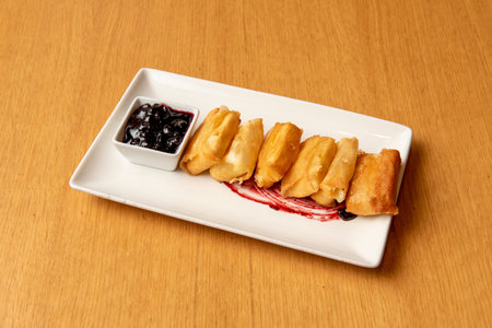Crispy cheese fried in olive oil with blueberry jam on white plate