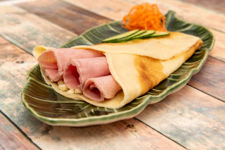 Salty French crepe filled with cooked ham, cheese and sliced fresh vegetablesの写真素材