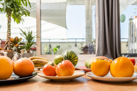 Pink tomatoes, ripe persimmons, grapefruits and mangoes between coursesの写真素材