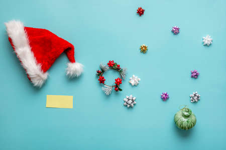 Christmas still life with Santa hat, stars, decorations and yellow noteの写真素材