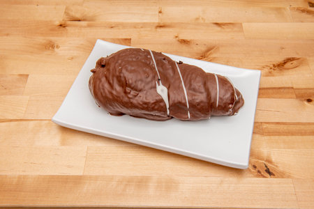 Chocolate horn filled with cream on white plate