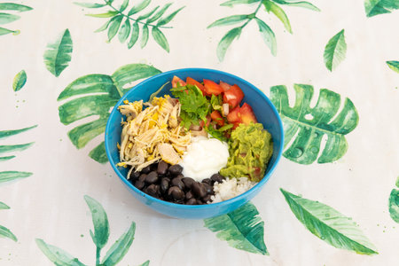 Mexican Poke Bowl with Chicken, Black Beans, Cream Cheese, Ripe Guacamole, Chopped Tomatoes, Cilantro, and Cooked White Riceの写真素材