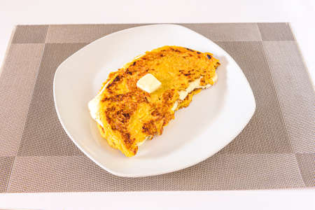 Cachapa is a typical corn-based dish stuffed with fresh cheese on a white plateの写真素材