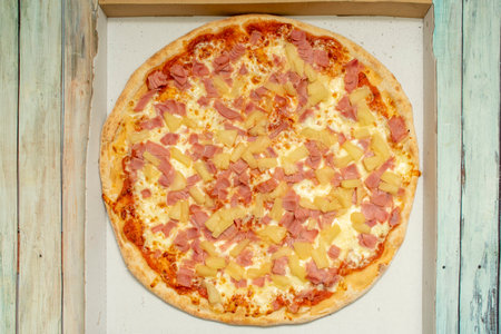 Hawaiian pizza contains a base of melted cheese and tomato with ham and pineapple. Some include bacon, shrimp, cherries, red peppers, mushrooms, onions or jalapeÃ±os, pineapple is always presentの写真素材