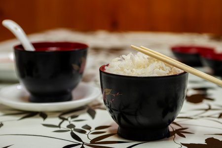 Bowls of Japanese white rice and miso soup with chopsticks and spoon for eating