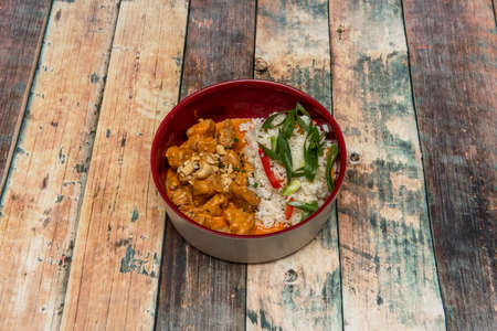red curry very popular in Thai cuisine with coconut milk heated with red curry paste and fish sauce. Different meat contents are usually added to the mixture as well as Thai basilの写真素材