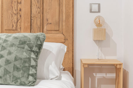 bedroom with a double bed with a rustic headboard with unvarnished wooden shutters, green cushions...
