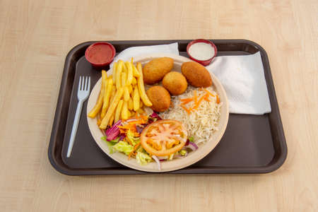 Combined plate with croquettes, cooked white rice, salad with lettuce and tomato and French fries with saucesの写真素材
