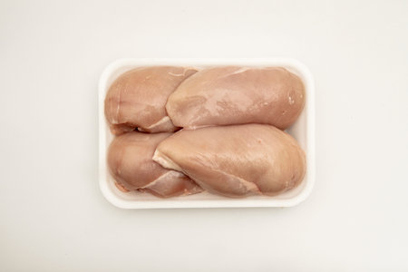 Breasts of several clean and raw chickens in a polystyrene container