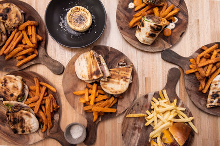 Lots of Spanish sandwiches with assorted fillings, tarts and fried potatoes and fried sweet potatoesの写真素材