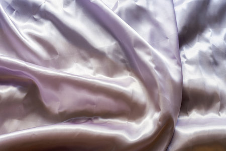 satin fabric background of a pearly pinkish tone with water and wrinklesの写真素材