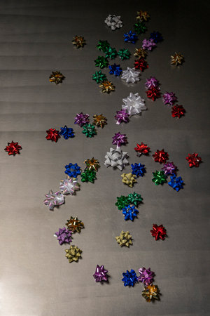 Bold bright colored wrapping paper stars forming patterns on a shiny gray textureの写真素材