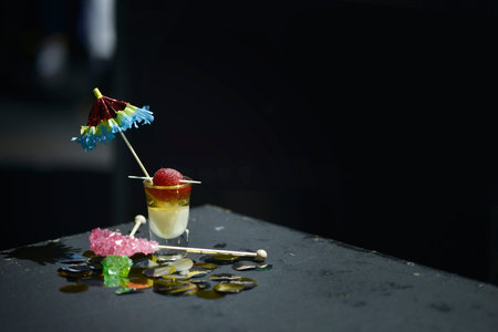 An exotic drink of alcohol with colored sugar and a parasol