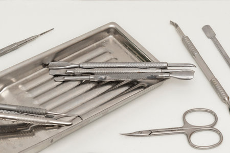Utensils for cleaning and caring for nails on a stainless steel tray on a white wooden cabinet in a beauty salonの写真素材