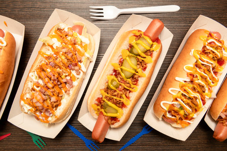 A string of delicious hot dogs from different recipes in paper gondolasの写真素材