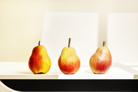 A trio of pears by the light of a windowの写真素材