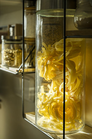Shelf with seasonings and pastes in large jars in glass close-up on a kitchen wallの写真素材