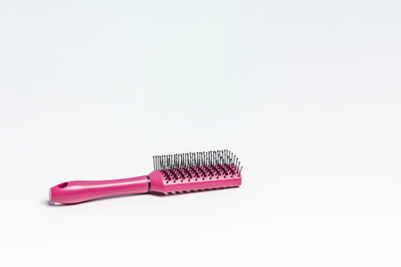 New purple hairbrush with black bristles on a white bathroom cabinet