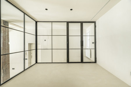 Room of a loft apartment with glass partitions and black metal structureの写真素材