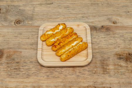 Some mozzarella sticks breaded and fried in deep fryer oilの写真素材