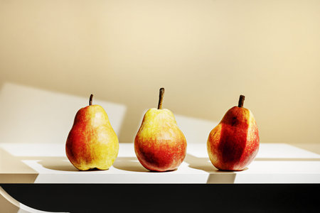 A trio of pears by the light of a windowの写真素材