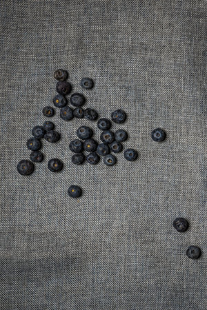 overhead shot of handful of ripe blueberries on gray linen clothの写真素材