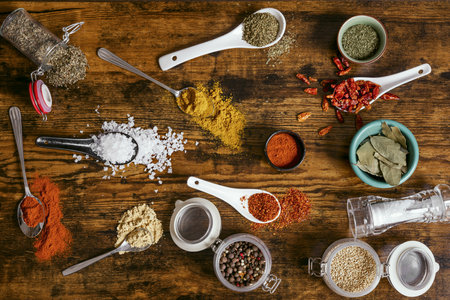 top view of set of spoons and jars with all kinds of kitchen spices and condimentsの写真素材