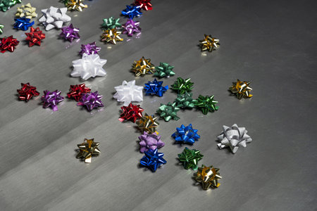 Wrapping paper stars in bold colors, bright white, gold, cobalt blue, passion red, forming patterns on a shimmering gray textureの写真素材