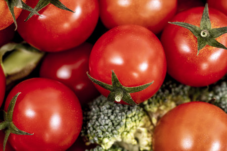 close up of bulk cherry tomatoes and broccoli sprigsの写真素材