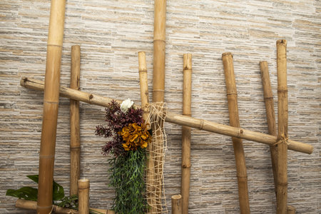 Decoration with bamboo tubes and artificial plants on a stone-like wallの写真素材