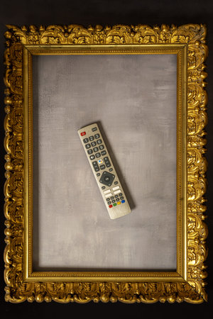 A tv remote with a wooden gilt frame