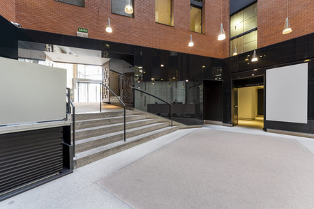 Atrium of an office building with granite stairs, metal railings and pendant lamps