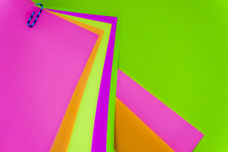 some colored paper bags with a blue clip holding themの写真素材