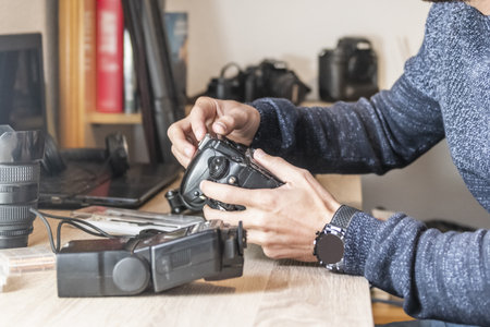 A photographer cleaning his equipment on an office tableの写真素材