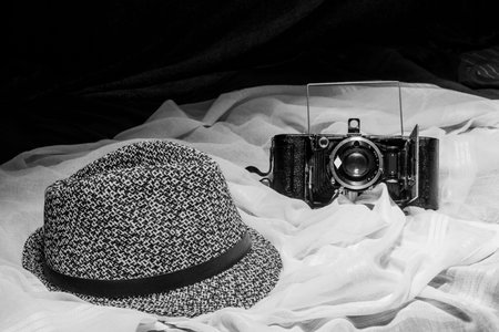 A simple black and white still life with a jean hat and a vintage photo cameraの写真素材